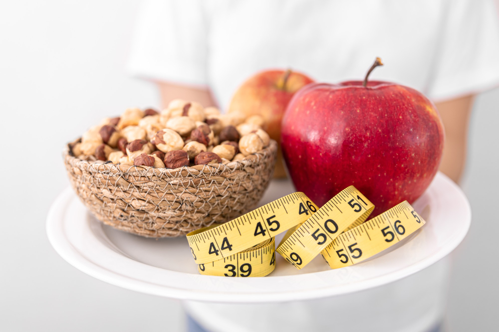 plate with apples nuts measuring tape diet healthy food concept