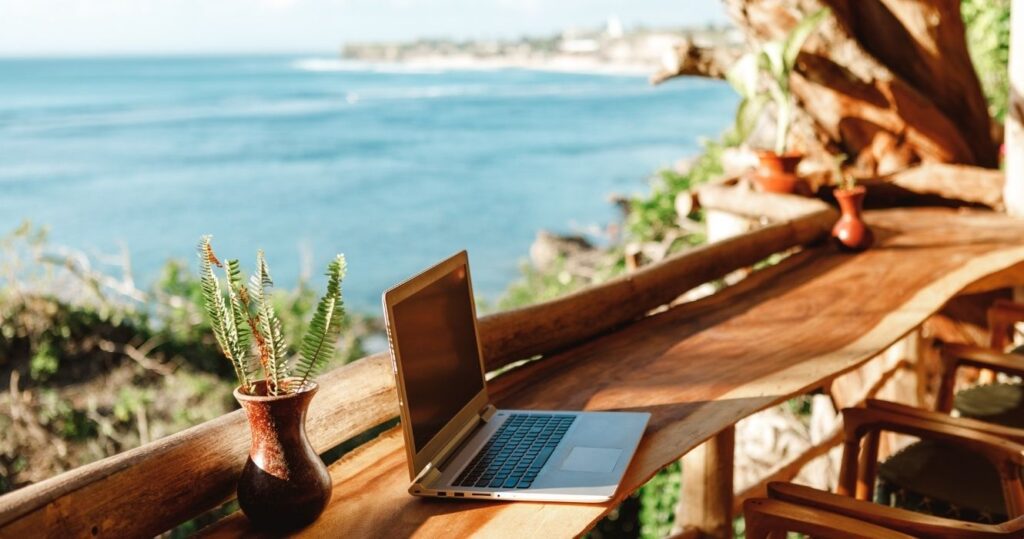 a laptop outside on a tropical island