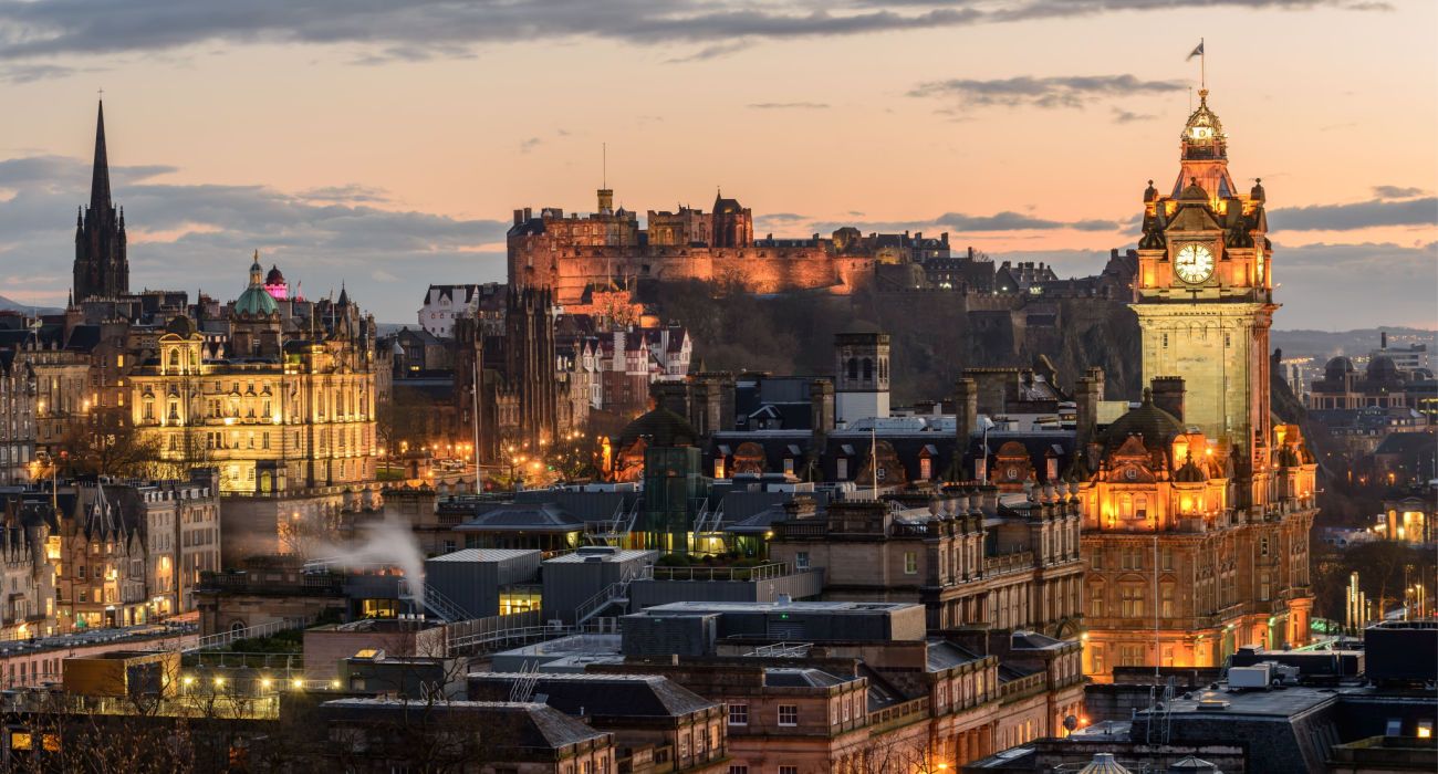 Castelo de Edimburgo e Princes Street ao pôr do sol.