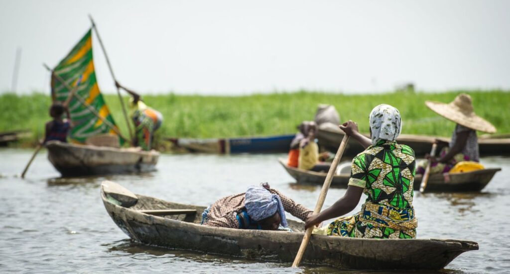Beninese woman raws a fishing boat
