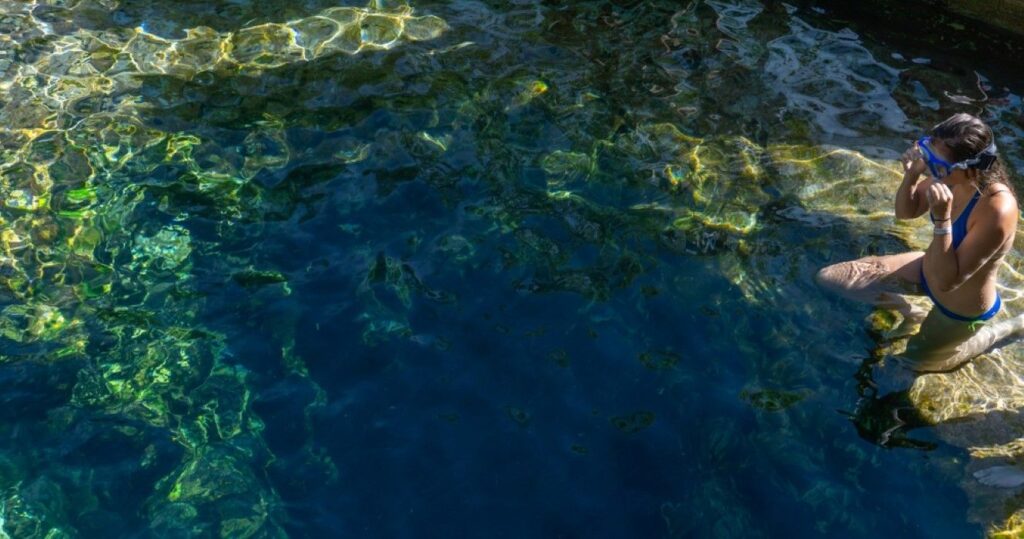 Girl preparing to dive in Jacob's Well, Texas