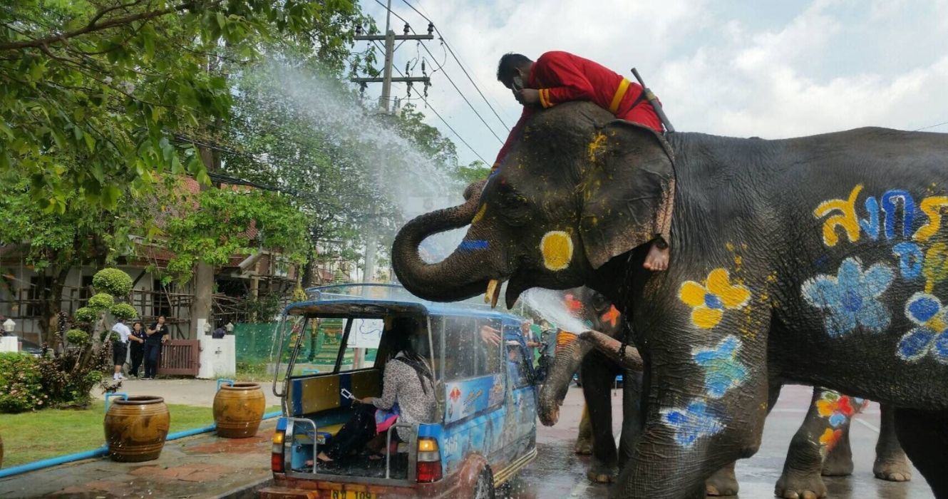 Elefante jogando água nas pessoas durante Songkran na Tailândia