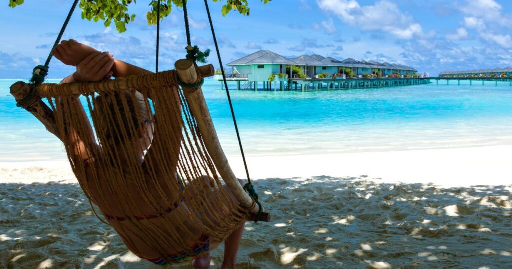 a traveler relaxing in a hammock on the beach in jamaica