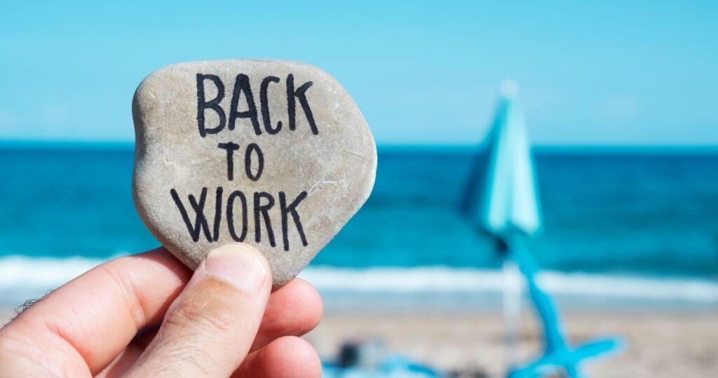 a rock at the beach that says 'back to work'