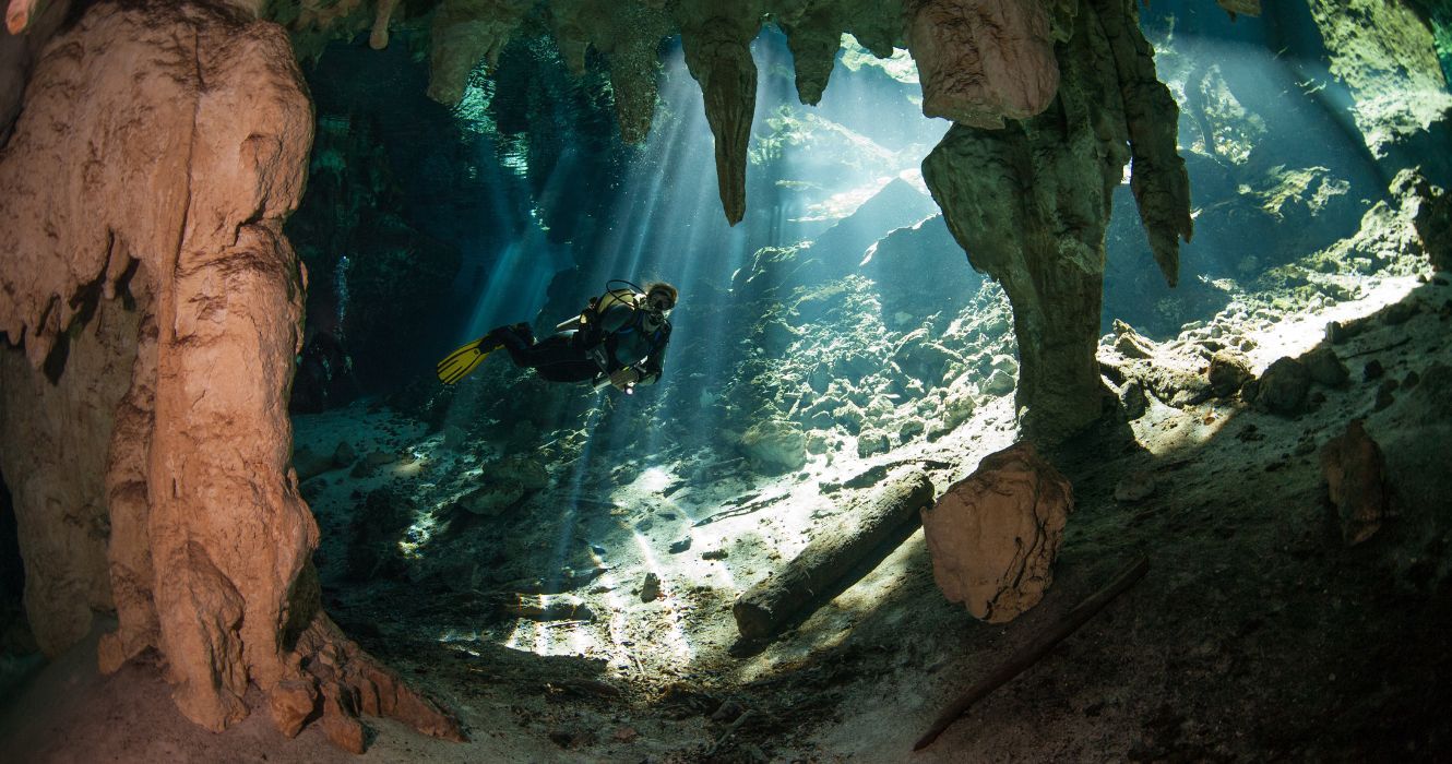 uma caverna de mergulhador mergulhando em uma caverna subaquática