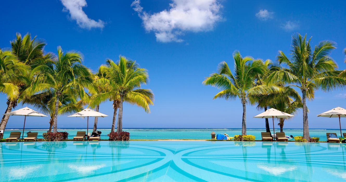 um resort na praia com piscina e palmeiras